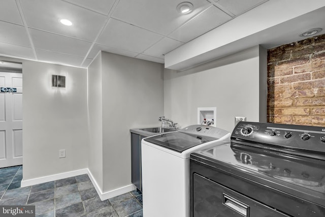 clothes washing area featuring separate washer and dryer and sink