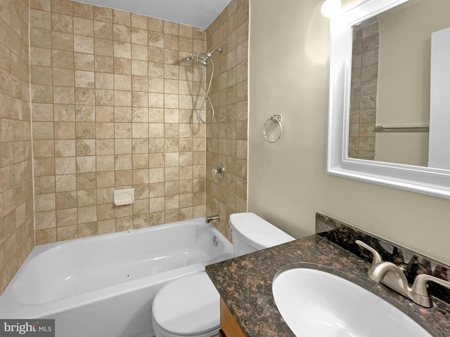 full bathroom featuring vanity, tiled shower / bath combo, and toilet