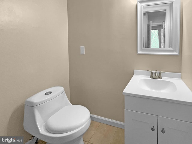 bathroom featuring toilet, vanity, and baseboards