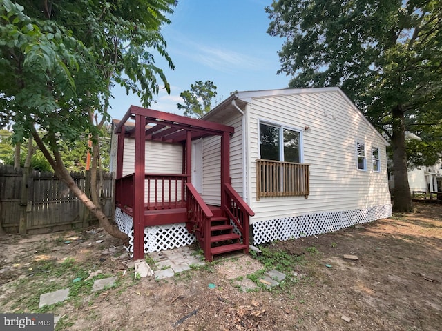 back of property with a pergola and a wooden deck