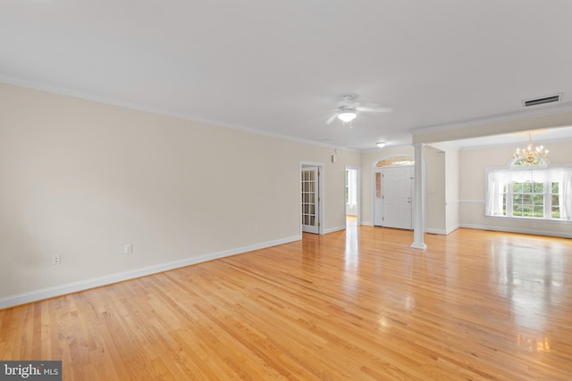 empty room featuring light wood-type flooring, ceiling fan with notable chandelier, decorative columns, and crown molding