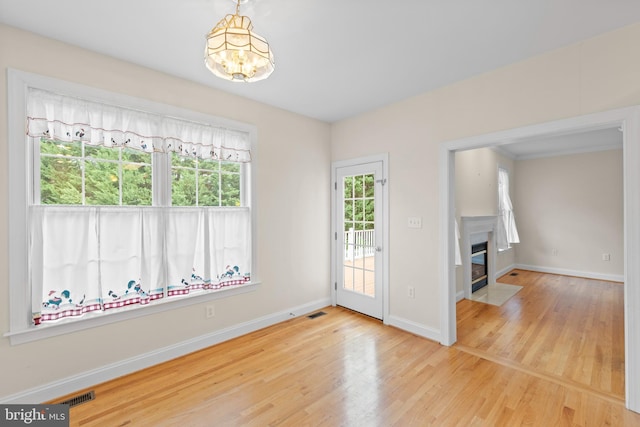 empty room featuring wood-type flooring and a chandelier