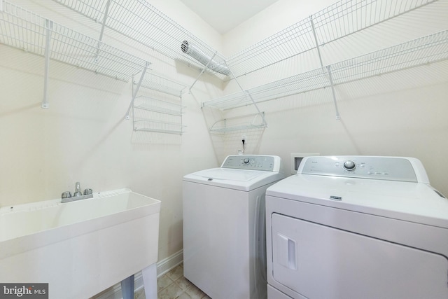 clothes washing area featuring sink and washing machine and dryer