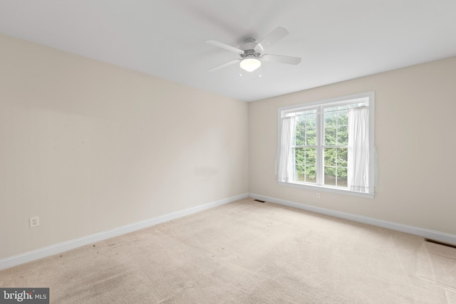 empty room with ceiling fan and light colored carpet