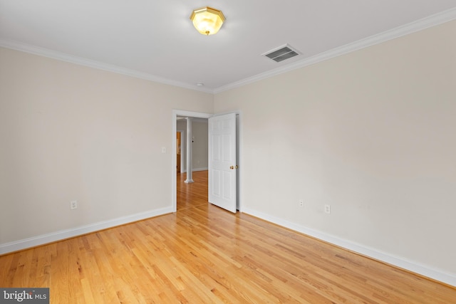 empty room with light hardwood / wood-style flooring and crown molding