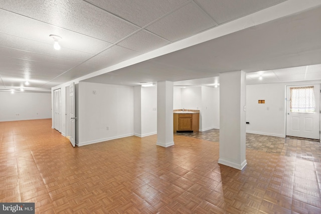 basement with parquet flooring and sink