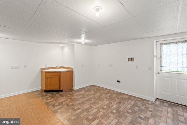 interior space featuring a drop ceiling and sink