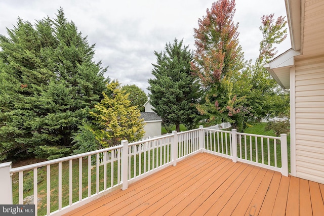 wooden terrace featuring a lawn