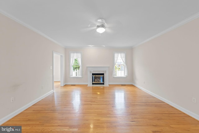 unfurnished living room featuring ornamental molding, light hardwood / wood-style floors, a premium fireplace, and ceiling fan