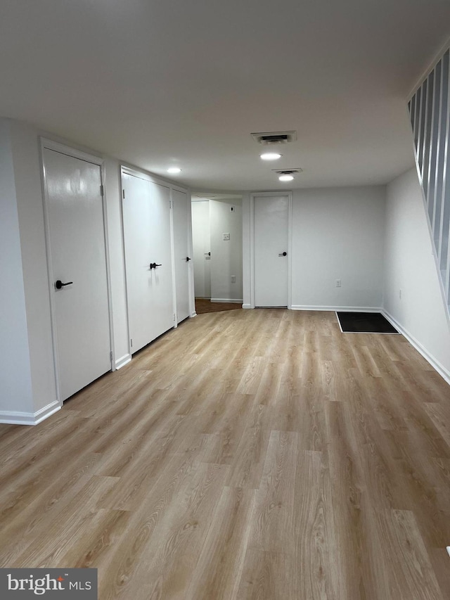 empty room with baseboards, visible vents, and light wood-style floors