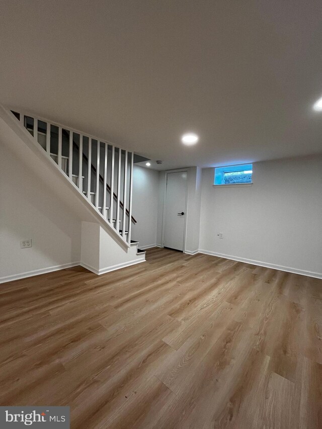 basement with light hardwood / wood-style flooring