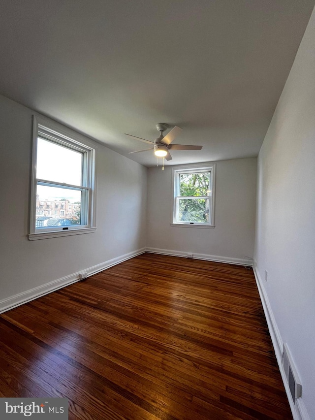 unfurnished room with ceiling fan and dark wood-type flooring