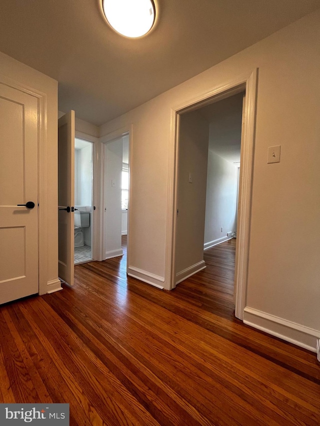 unfurnished room featuring dark wood finished floors and baseboards