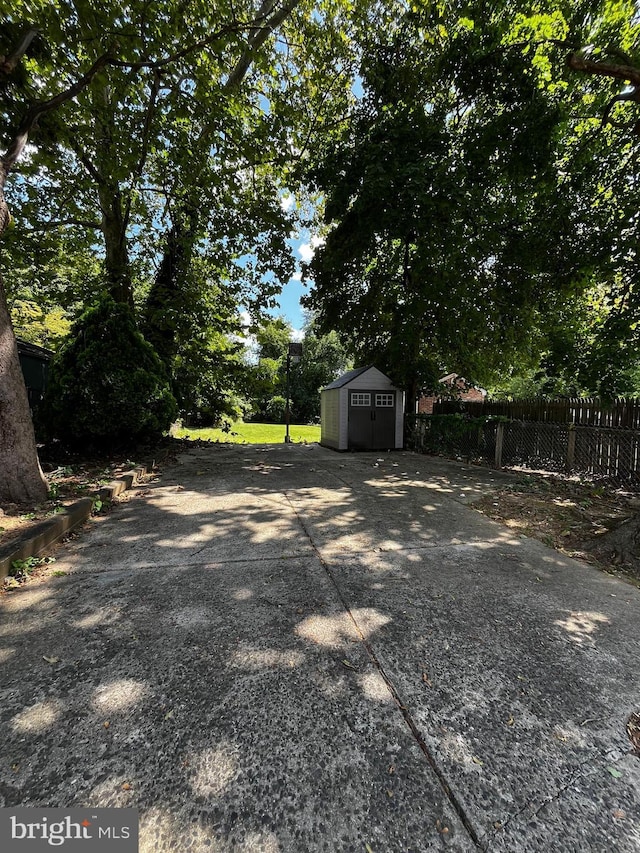 view of yard with a storage shed, fence, and an outdoor structure