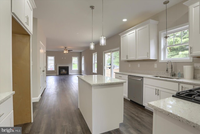 kitchen featuring plenty of natural light, stainless steel dishwasher, sink, and white cabinetry