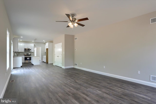 unfurnished living room featuring ceiling fan, dark hardwood / wood-style floors, and sink