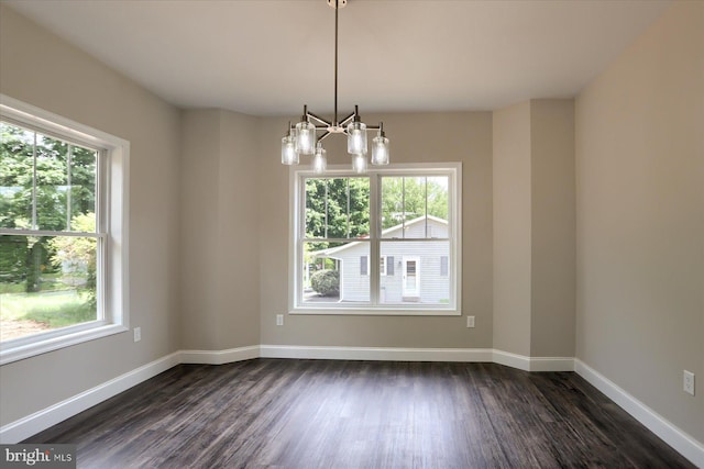 unfurnished room featuring dark hardwood / wood-style flooring and a notable chandelier