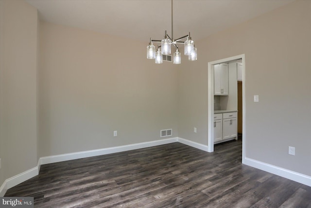 unfurnished dining area featuring dark wood-type flooring and a notable chandelier