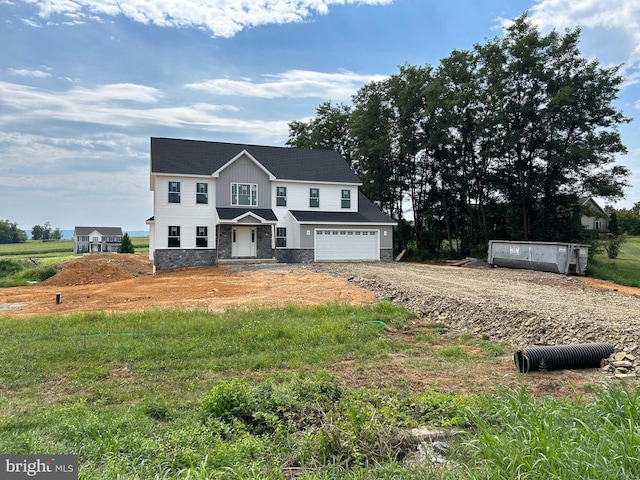 view of front of house featuring a garage, stone siding, driveway, and board and batten siding