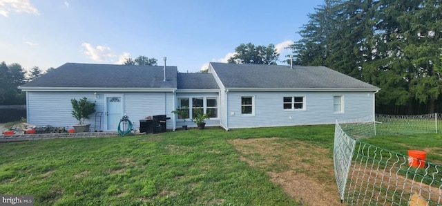 rear view of property with a yard and fence