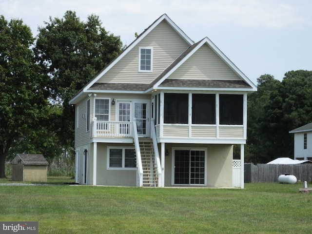 back of house featuring roof with shingles, a lawn, stairway, a sunroom, and fence