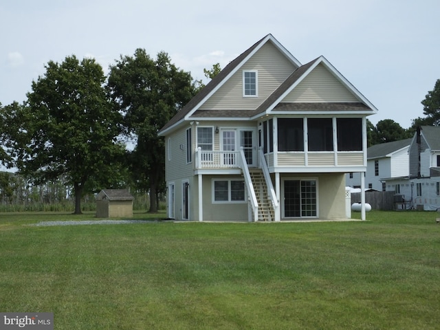 view of front of property featuring a sunroom, stairway, an outbuilding, a storage unit, and a front yard