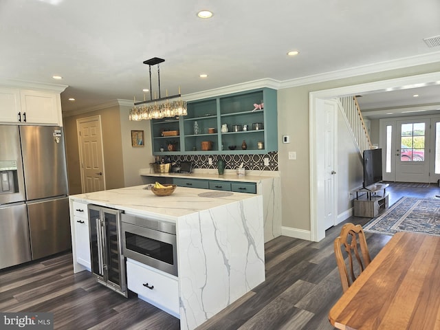 kitchen with wine cooler, open shelves, appliances with stainless steel finishes, white cabinets, and a kitchen island