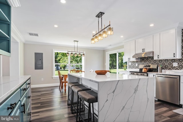 kitchen with a kitchen island, a healthy amount of sunlight, appliances with stainless steel finishes, and white cabinetry