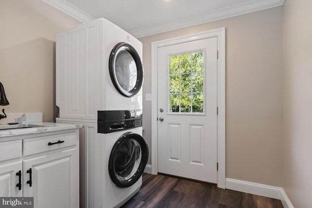 laundry room with dark wood-style flooring, cabinet space, ornamental molding, a sink, and stacked washing maching and dryer