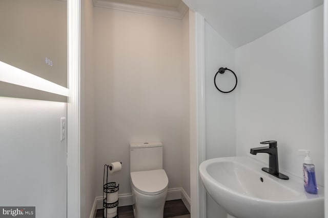 bathroom featuring vaulted ceiling, toilet, hardwood / wood-style floors, and sink