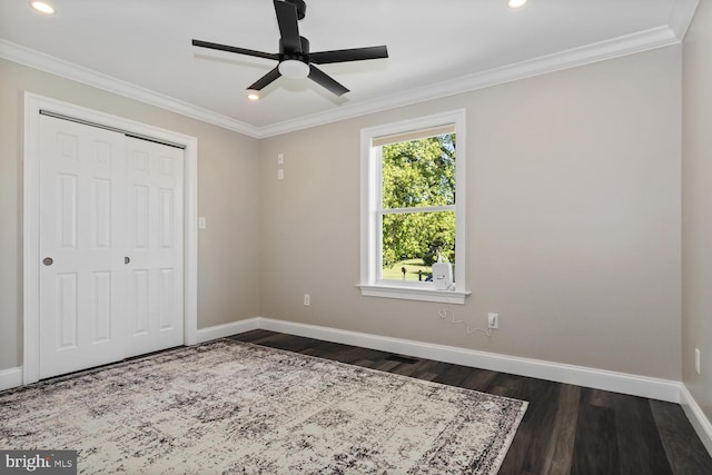 unfurnished bedroom with dark hardwood / wood-style floors, ornamental molding, ceiling fan, and a closet