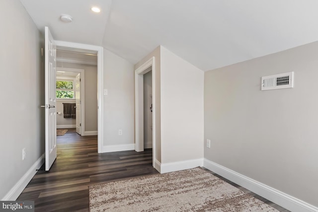 interior space featuring vaulted ceiling and dark hardwood / wood-style flooring