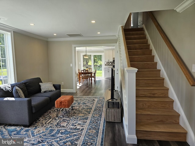 living room with crown molding, plenty of natural light, and dark hardwood / wood-style floors