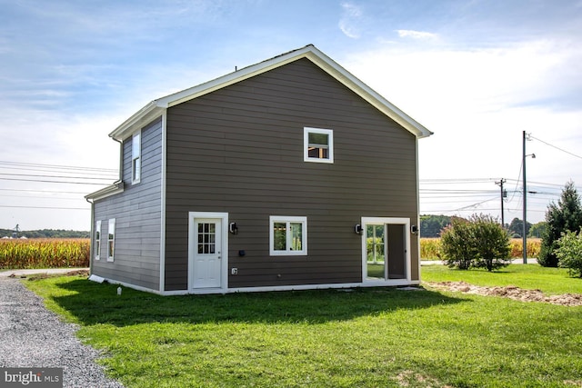 back of house with a lawn