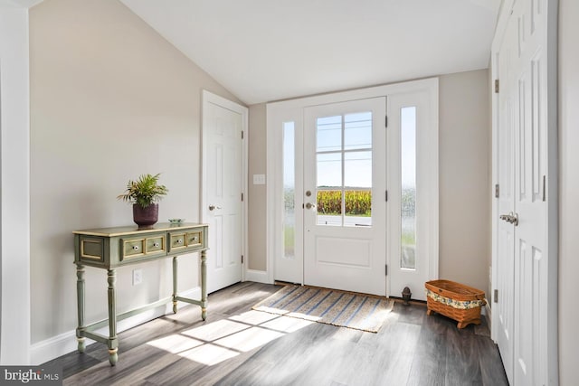 doorway to outside with lofted ceiling, baseboards, and wood finished floors