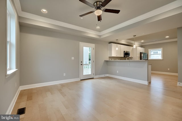 unfurnished living room with ceiling fan, plenty of natural light, and light hardwood / wood-style floors