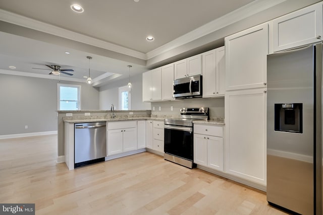 kitchen featuring appliances with stainless steel finishes, hanging light fixtures, white cabinetry, light wood-type flooring, and ceiling fan