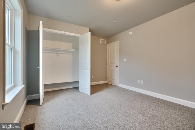 unfurnished bedroom with carpet flooring and a closet