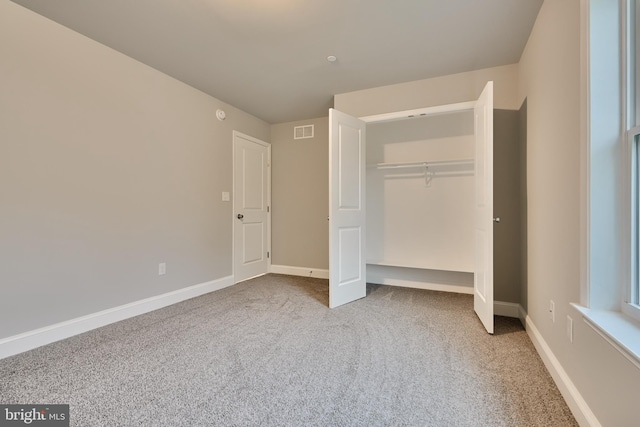 unfurnished bedroom with a closet and carpet flooring