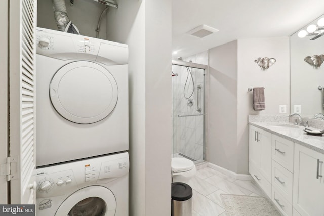 interior space featuring light tile patterned floors, stacked washer and clothes dryer, and sink