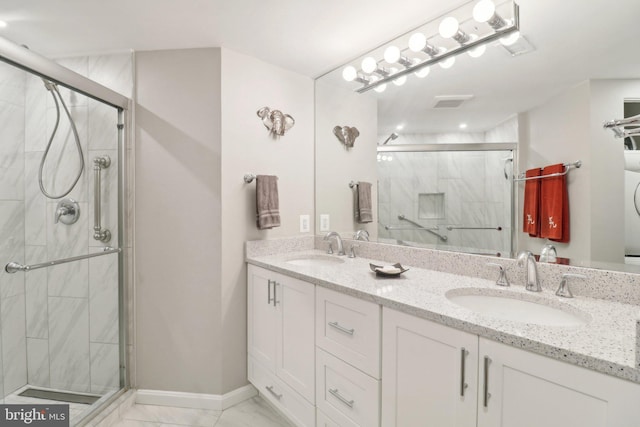 bathroom featuring double vanity, a stall shower, marble finish floor, and a sink