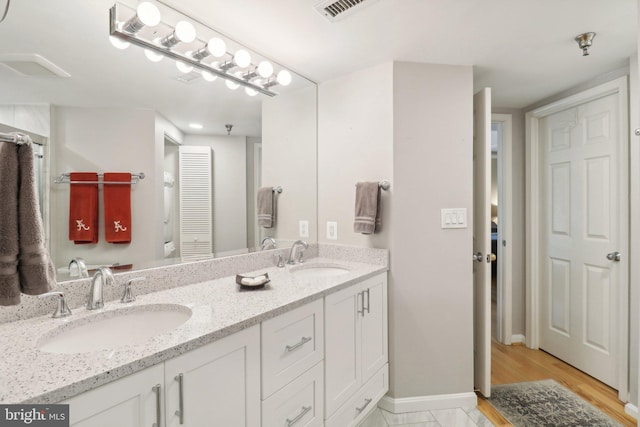 bathroom featuring double vanity, a closet, visible vents, and a sink