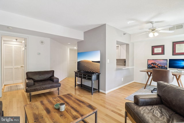 living room with a ceiling fan, light wood-type flooring, visible vents, and baseboards