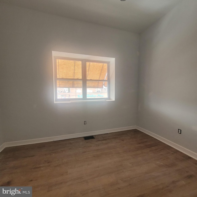 spare room featuring dark wood-type flooring