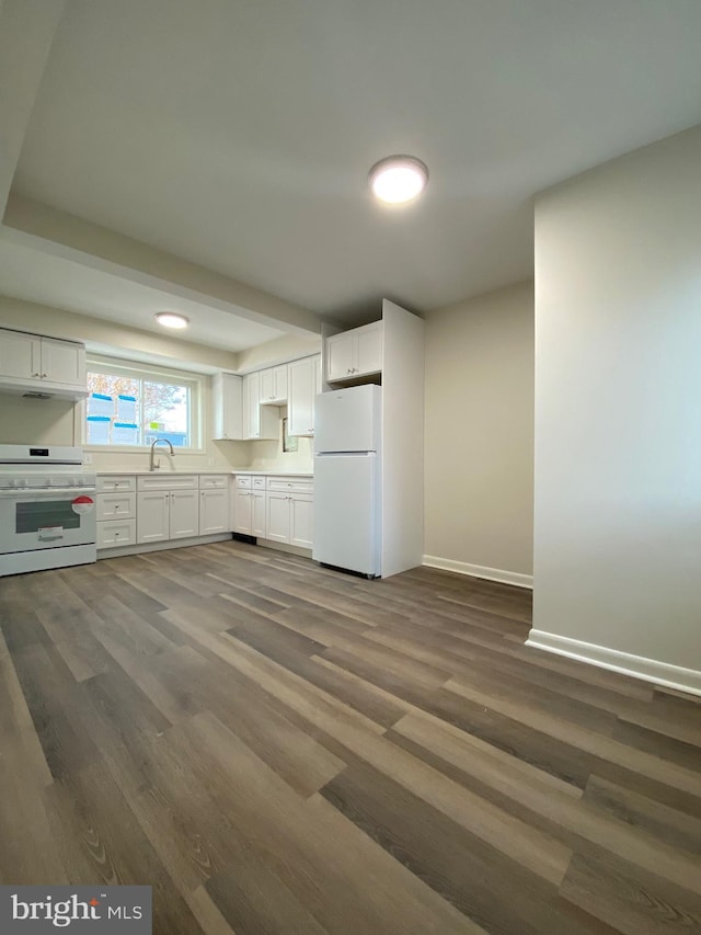 kitchen featuring dark hardwood / wood-style floors, sink, white cabinets, and white appliances