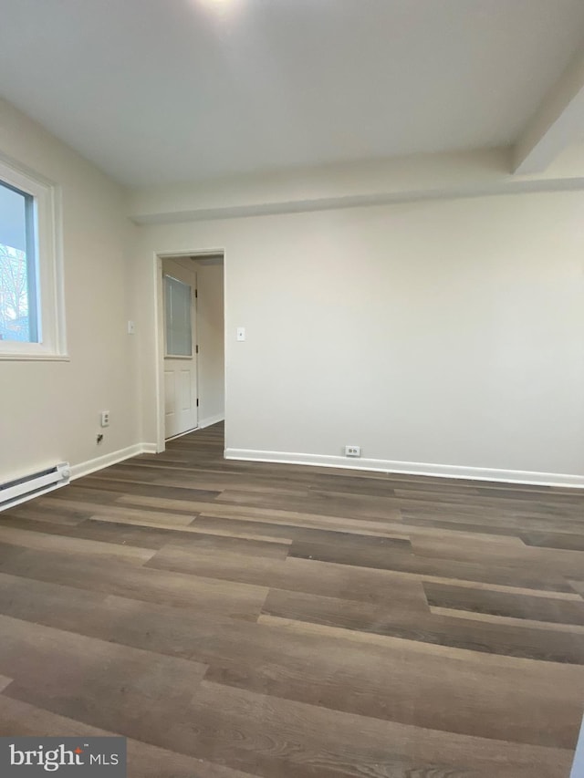 spare room with dark hardwood / wood-style floors and a baseboard radiator