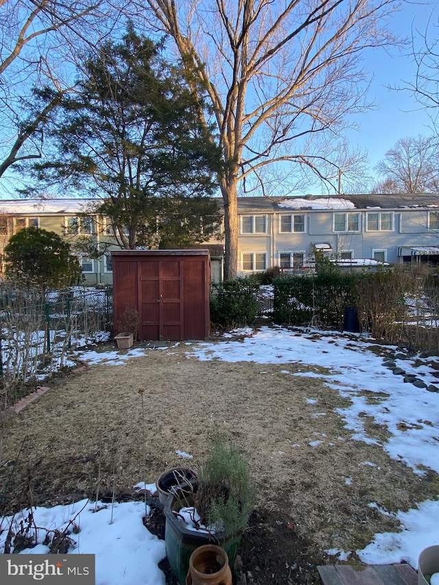 snowy yard with a storage unit