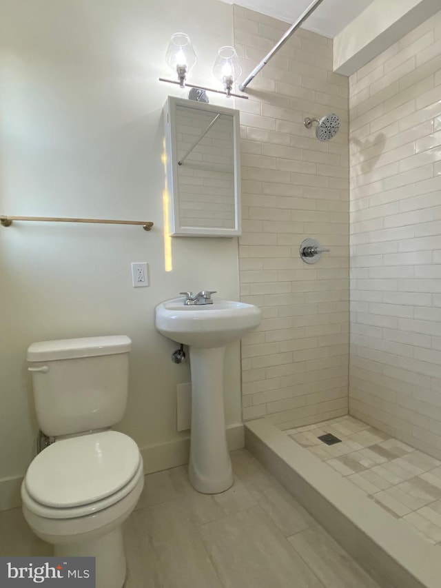 bathroom with toilet and a tile shower