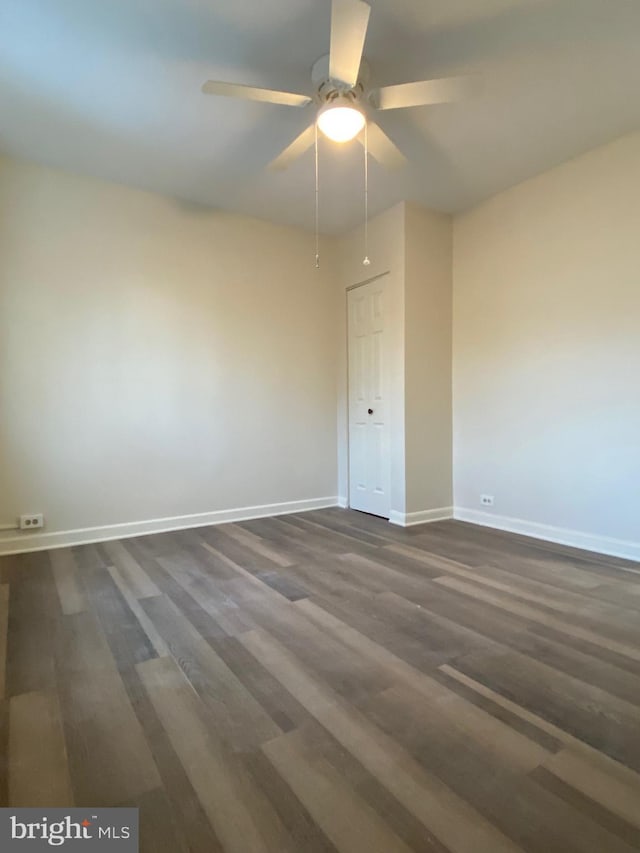 spare room featuring dark wood-type flooring and ceiling fan