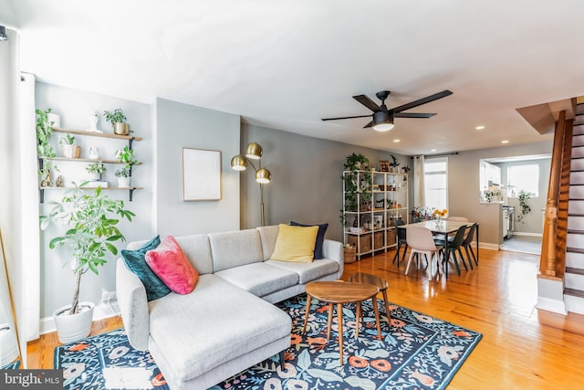 living room with ceiling fan, stairway, wood finished floors, and baseboards